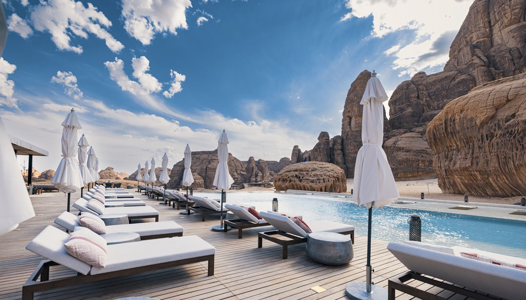 Scenic view of modern pool sun loungers on the wooden deck near the pool at the Habitas resort